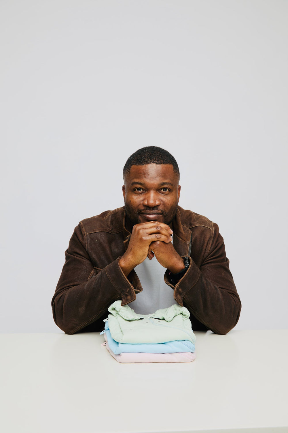 Nolele founder Oge Edward at a table with a stack of folded Swaddle Easy swaddles